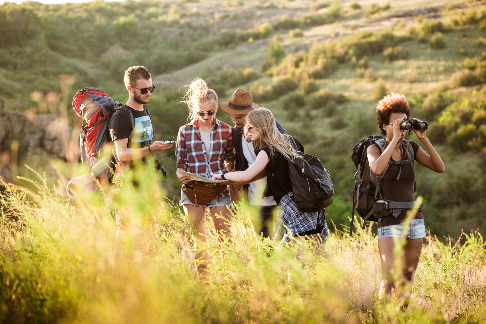 A smiling group of beginner hikers and cyclists on a scenic green trail outdoors.
